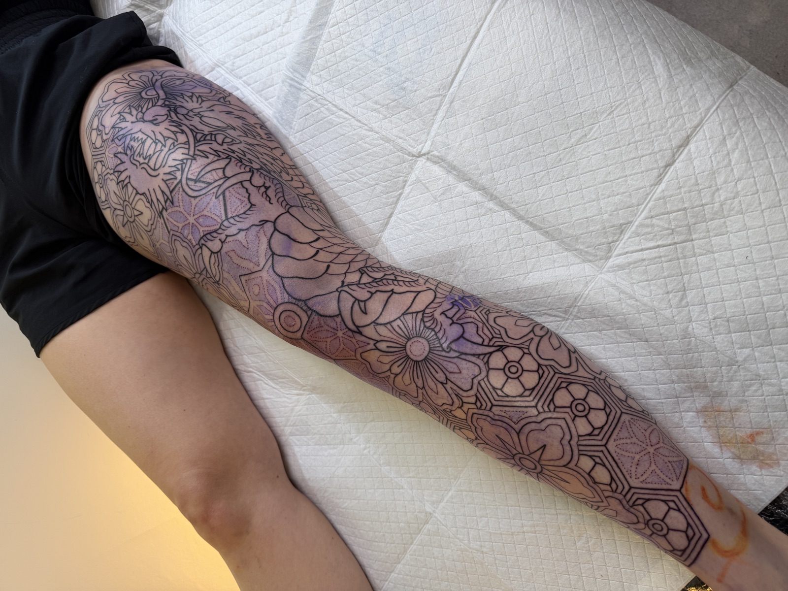 Japanese dragon and geometric blackwork leg sleeve in progress, by Si, Bristol