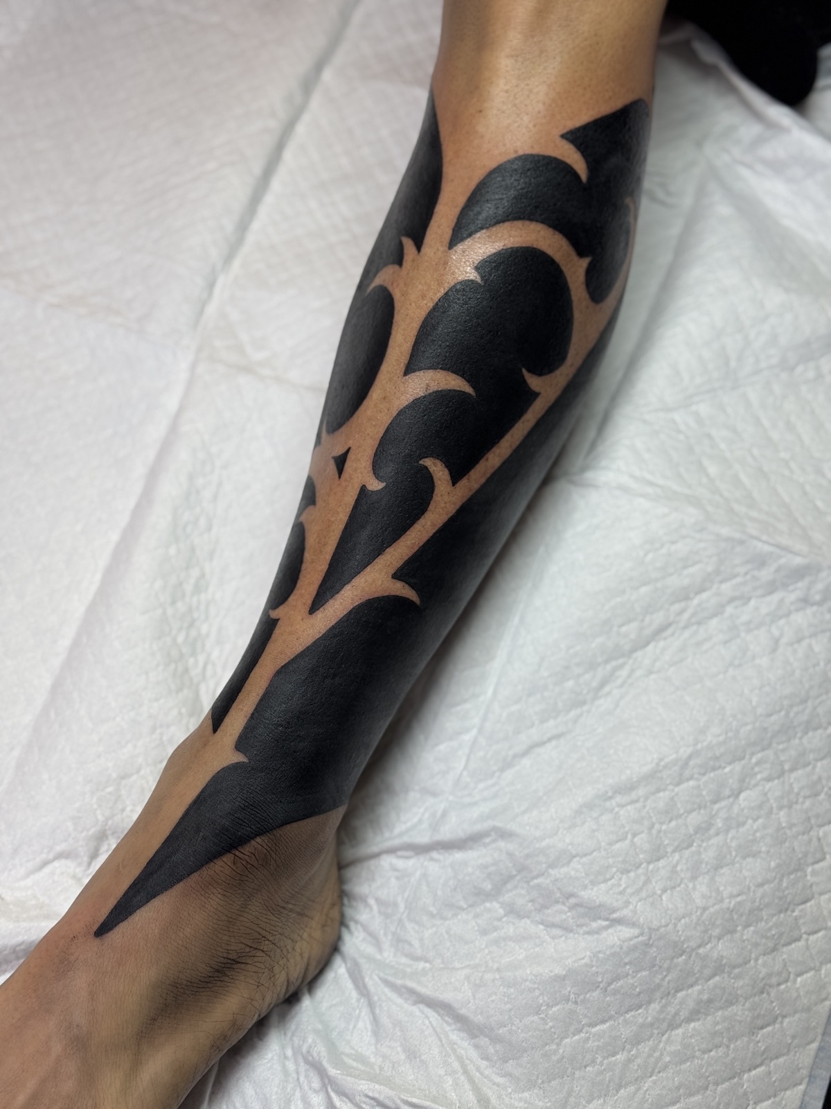 Neo-tribal blackwork covering the front of the shin, old tattoo gone, by Si, Bristol